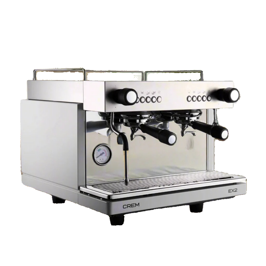 Crem EX2 espresso machine on a wooden surface with a blurred indoor background