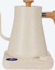 White electric kettle with wooden handle and spout on a white background